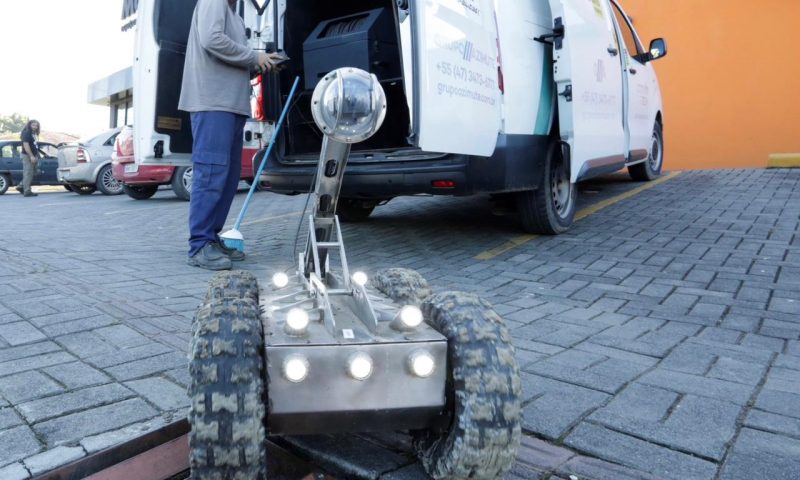 Técnicos manuseiam aparelho usado para vistoria nas galerias do Rio Mathias