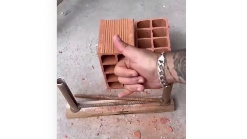 Pedreiro quebra o tijolo e mostra a máquina