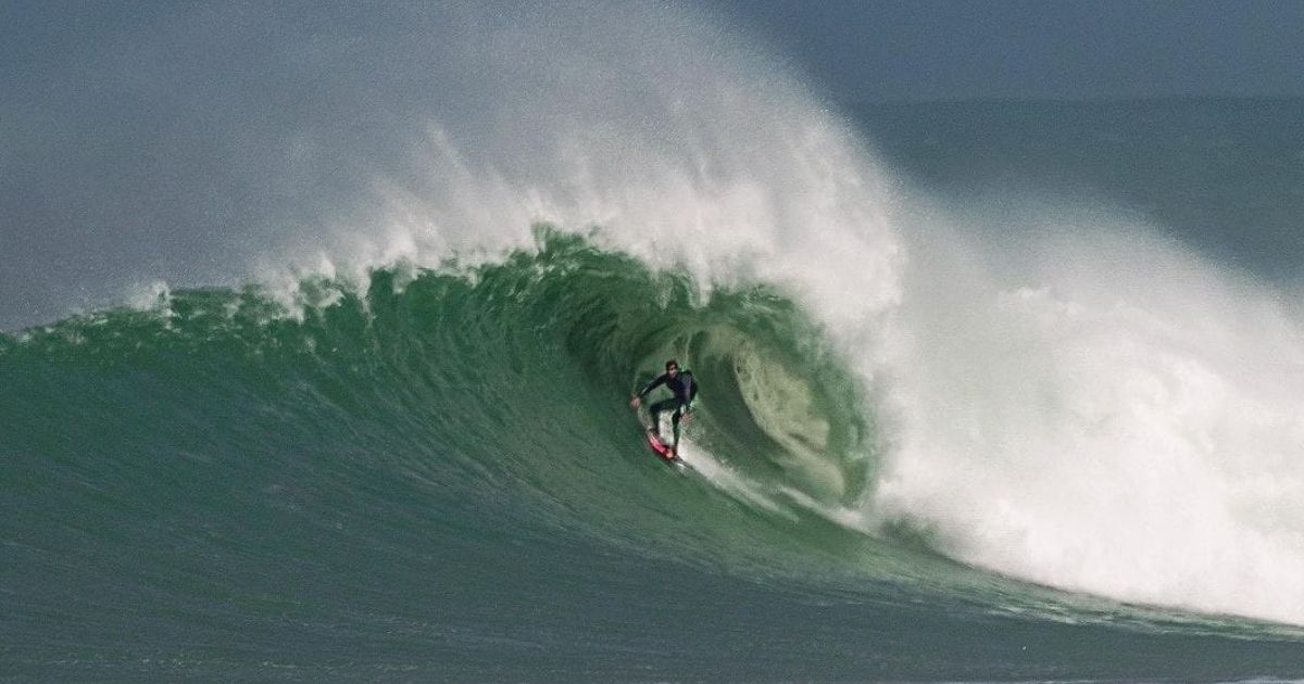 Imagem de uma onda grande com uma pessoa surfando, para fazer referência ao fato de que o sul de SC pé um exemplo de ondas gigantes em suas praias 