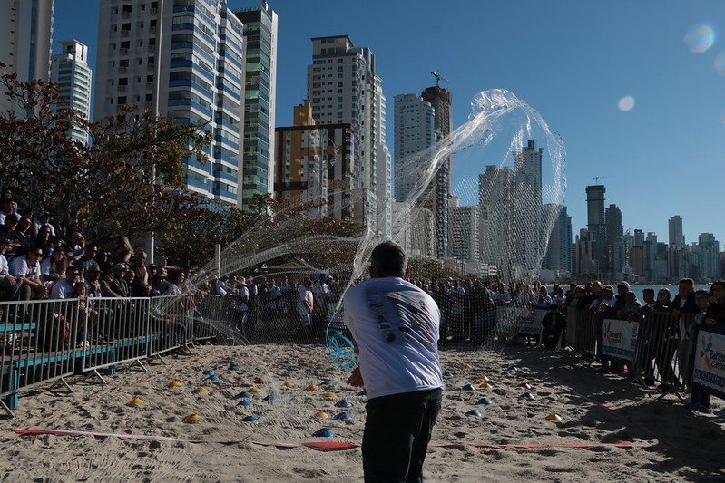 imagem na praia Central de Balneário Camboriú mostra pescador jogando rede utilizada na pesca da tainha