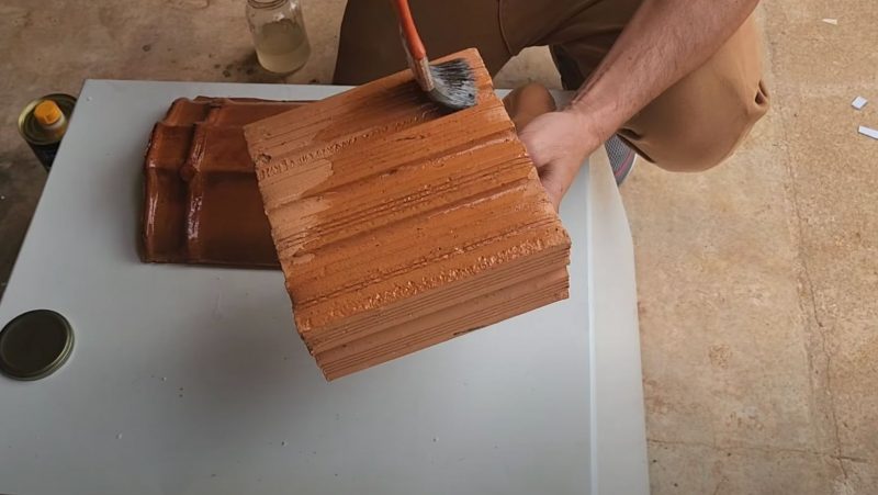 Pedreiro passa impermeabilizante em tijolo com pincel