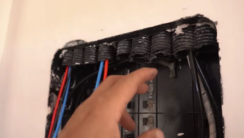 Eletricista examina tubos de conduítes por onde passam fios