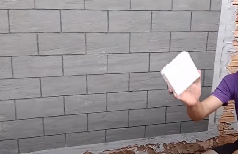 Pedreiro faz reboco diferenciado em muro de casa