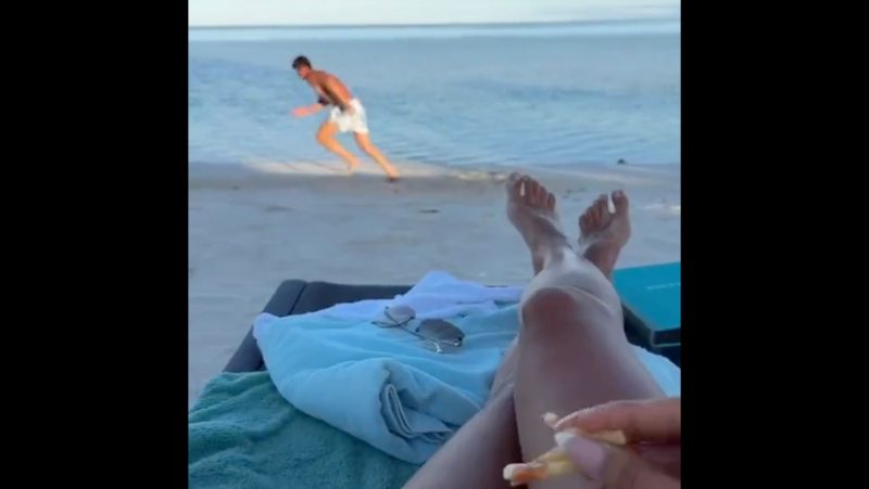 Ao fundo, Courtois “se matando” enquanto sua esposa curte a praia e uns petiscos – Foto: Reprodu&ccedil;&atilde;o