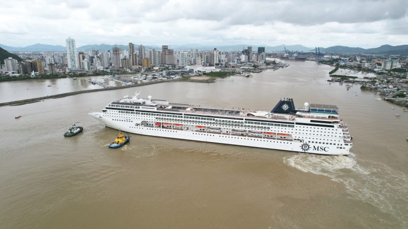 Foto de navio da MSC em Itajaí, com prédios ao fundo. Empresa terá cruzeiro saindo de Itajaí na temporada 2023-2024