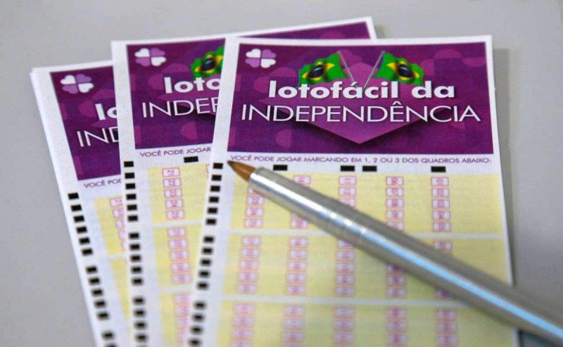 Prêmio da Lotofácil da Independência: bilhetes de apostas da loteria com caneta em cima de mesa 