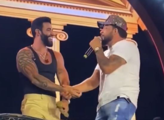 Gusttavo Lima passa a mão nas partes íntimas de cantor no palco; assista