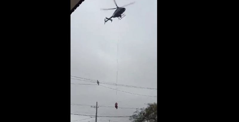 Moradores do Vale do Taquari que passaram a noite refugiados da enchente nos telhados de suas casas come&ccedil;am a se resgatados com ajuda de um helic&oacute;ptero – Foto: Reprodu&ccedil;&atilde;o/ND