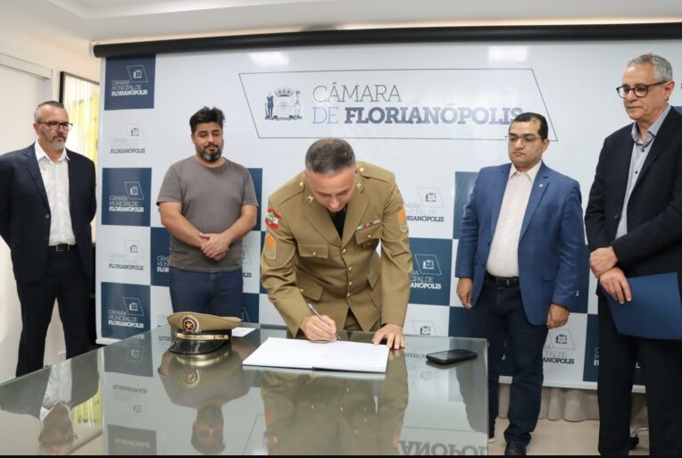 Passagem do cargo entre Maikon Costa [&agrave; esquerda, em p&eacute;] para o sargento M&aacute;rio Mattos [assinando] – Foto: CVF/Divulga&ccedil;&atilde;o/ND