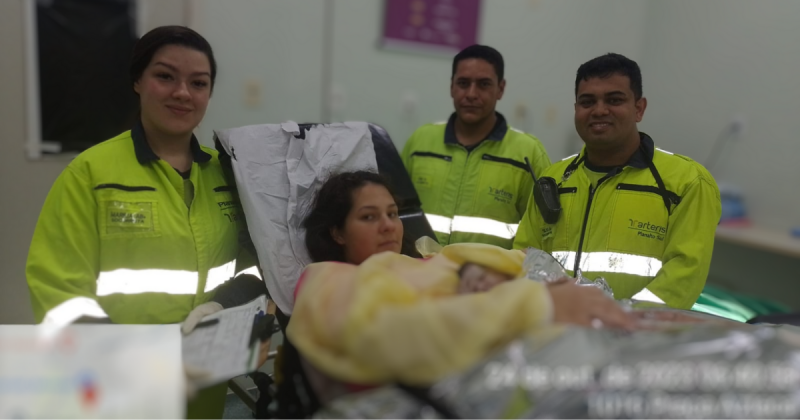 Após o nascimento, imagem mostra três socorristas da Arteris vestidos de verde com mãe segurando bebê no meio