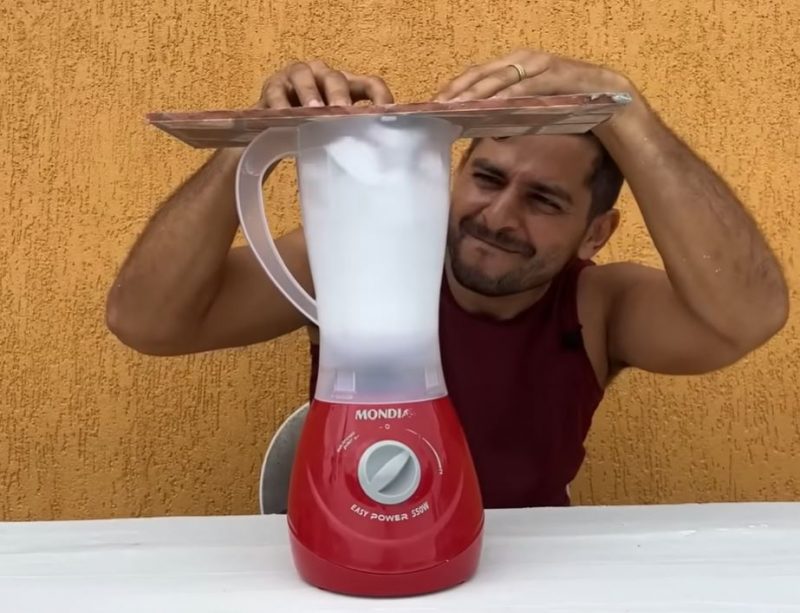O youtuber acrescenta pedaços de isopor e água em um liquidificador para conseguir fazer a mistura para a obra