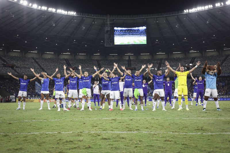 Jogadores do Cruzeiro reunidos no centro de campo comemoram a vitória no estádio do Mineirão