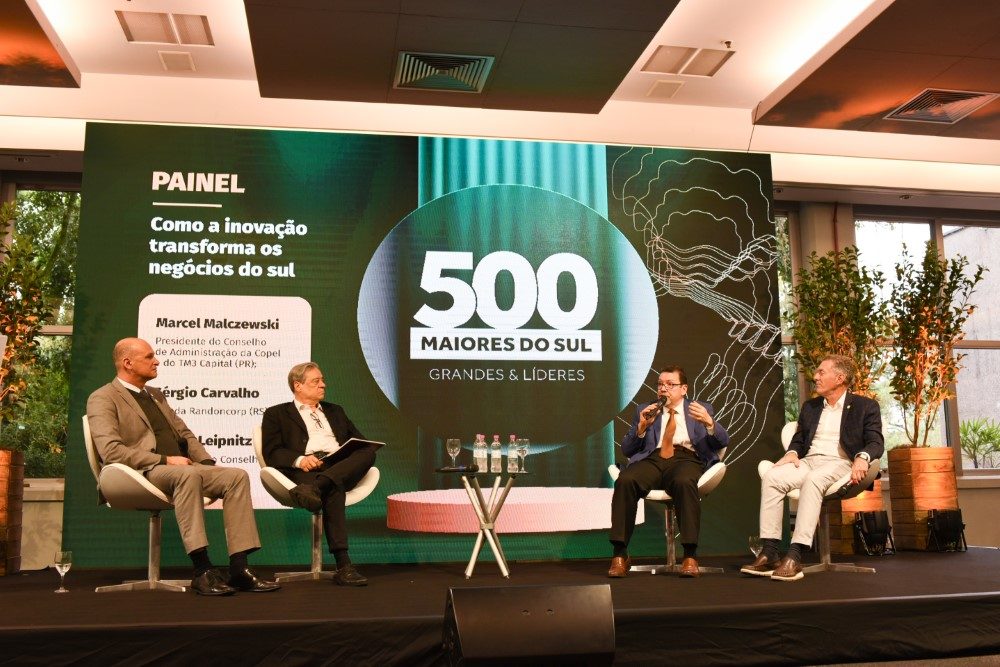 Na foto aparece quatro homens sentados em um palco discursando sobre o evento as 500 maiores empresas do Sul do Brasil.
