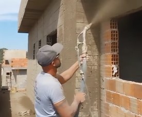 Pedreiro testa projetor de argamassa