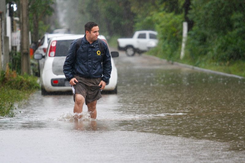 Morador enfrentando a chuva em Florianópolis