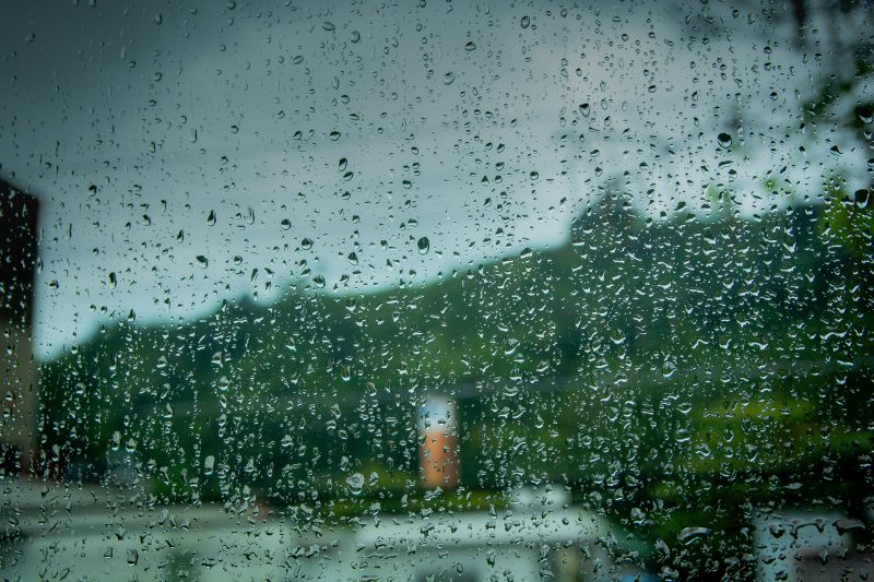 Imagem de gotas de chuva sobre uma janela; previsão do tempo para SC indica tempo instável no Litoral Norte