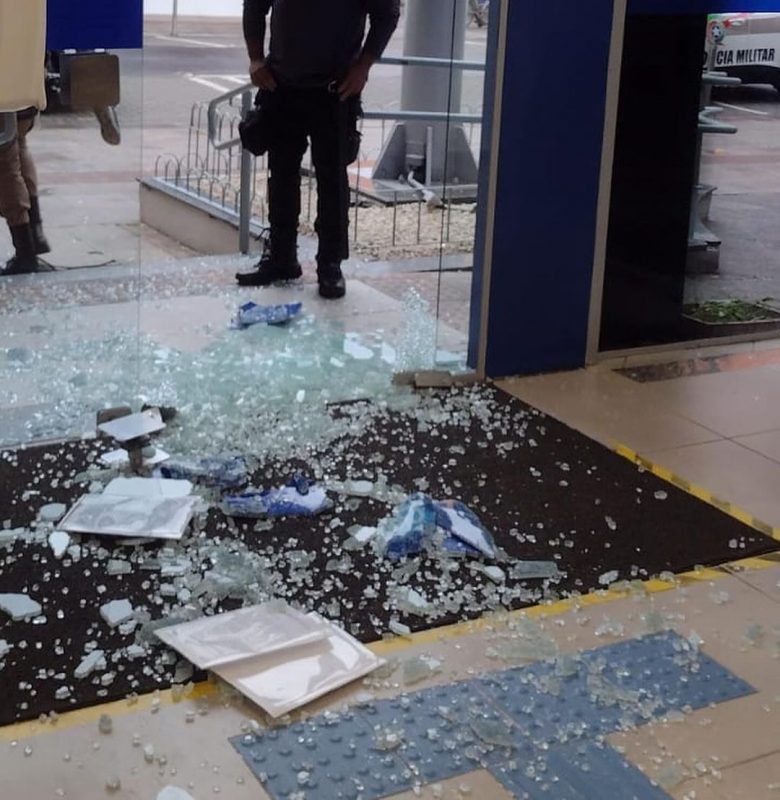 Homem quebra vidra&ccedil;a da porta de entrada de uma Ag&ecirc;ncia da Caixa Econ&ocirc;mica Federal, em Lages, na Serra catarinense. – Foto: Montagem/@biguataon/Reprodu&ccedil;&atilde;o/ND