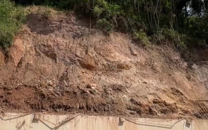 Pedaço de terra caindo sobre muro no bairro Santa Rita, em Brusque, com perigo de deslizamento