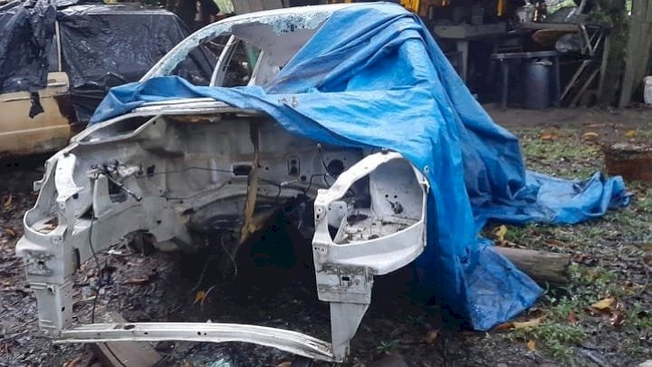 Imagem mostra a carcaça de um automóvel branco 