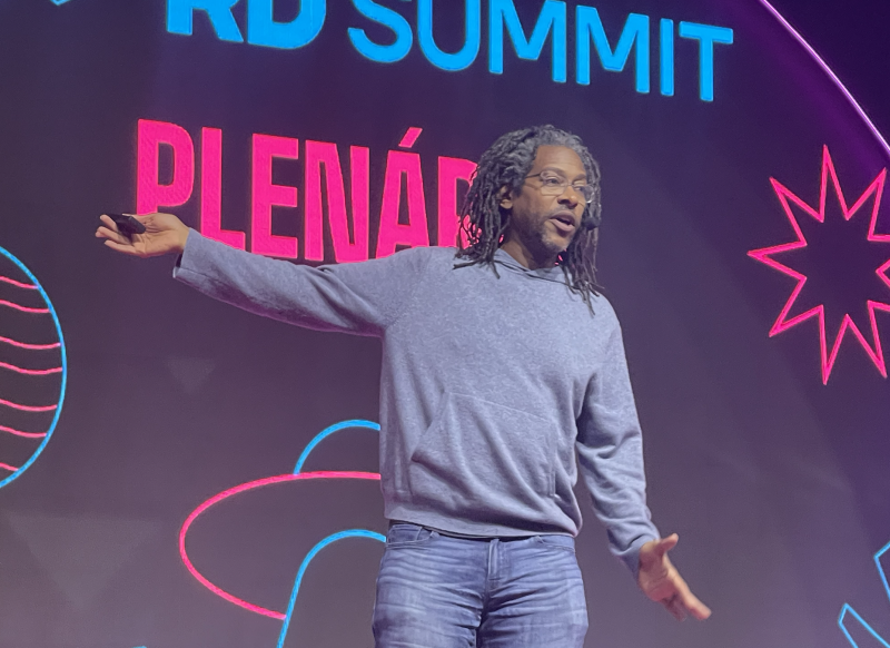 Na imagem, Will Reynolds está em um palco falando sobre uso de IA e dicas para o uso do ChatGPT