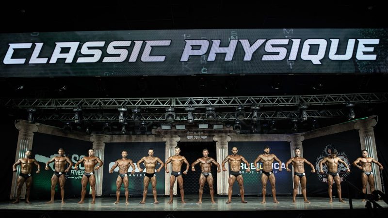 Atletas de fisiculturismo posando para jurados durante campeonato