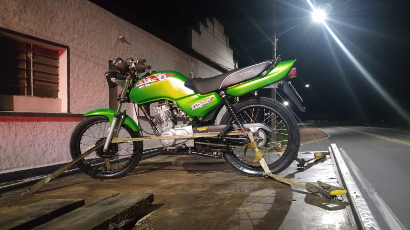 Motocicleta que participou da corrida presa em cima de guincho; moto tem cores verdes e pretas