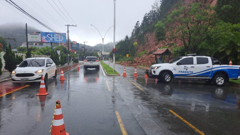 Deslizamento de terra em meio a rodovia em Balneário Camboriú; pista interditada com cones 