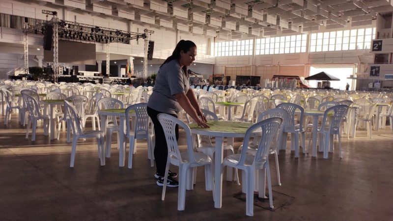 Foto mostra o local onde ocorrerá as atividades da Feira da Esperança, um salão cheio de cadeiras e um palco para os shows