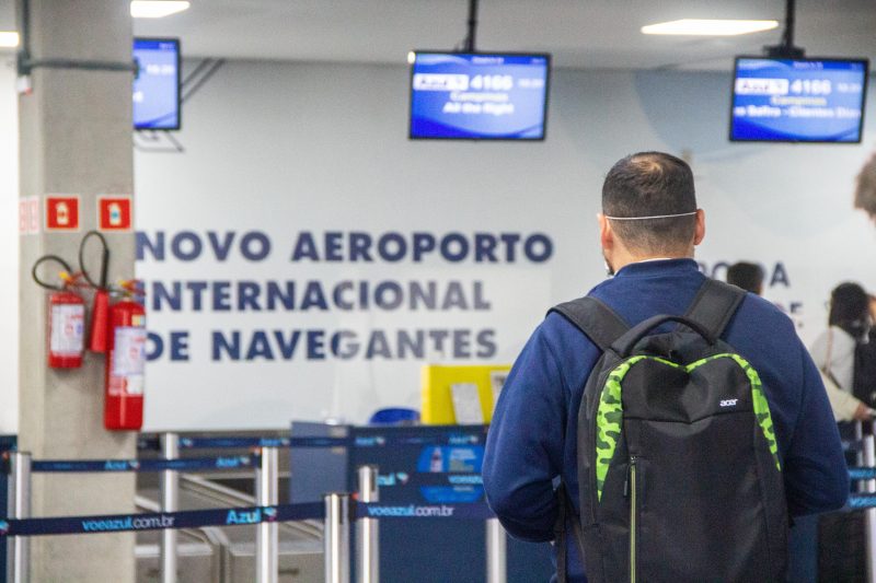 Homem comprando passagem de voo no aeroporto de Navegantes