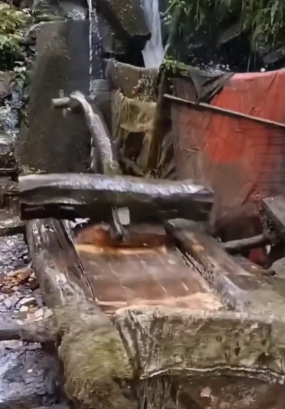 lavadora rudimentar feita de pedra e madeira