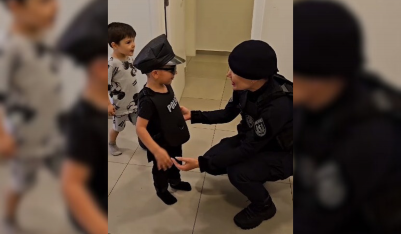 Menino vestido de minipolicial de frente para uma policial da Romu de Florianópolis