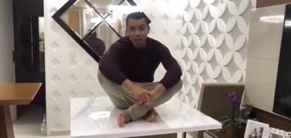 Pedreiro sentado em mesa de vidro feita com isopor