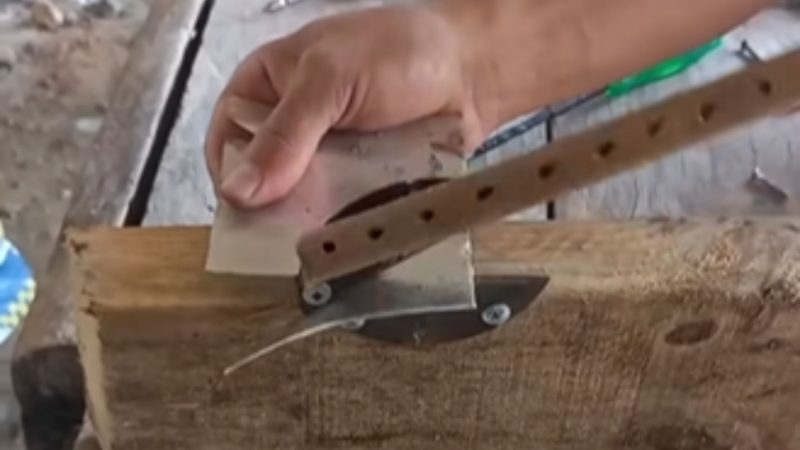 Pedreiro utilizando mini guilhotina construída para cortar lata