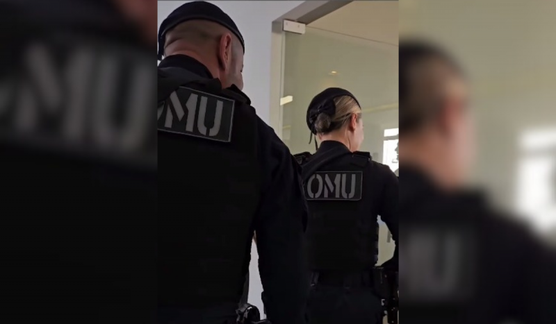 Dois agentes da Romu de Florianópolis de costas entrando por uma porta