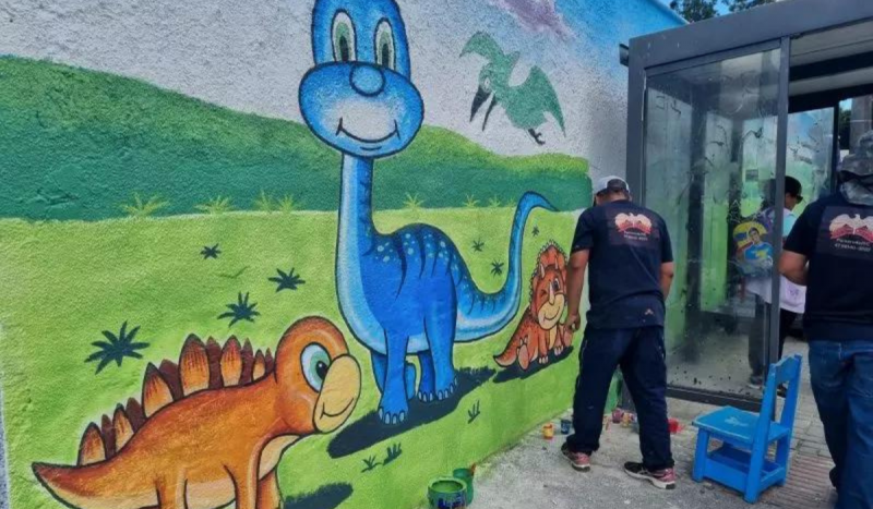 Muro de Centro Infantil em SC que sofreu ataque. Crianças foram vítimas de violência e quatro morreram. Muro pintado mostra 3 dinossauros, um grande azul e dois pequenos laranjas