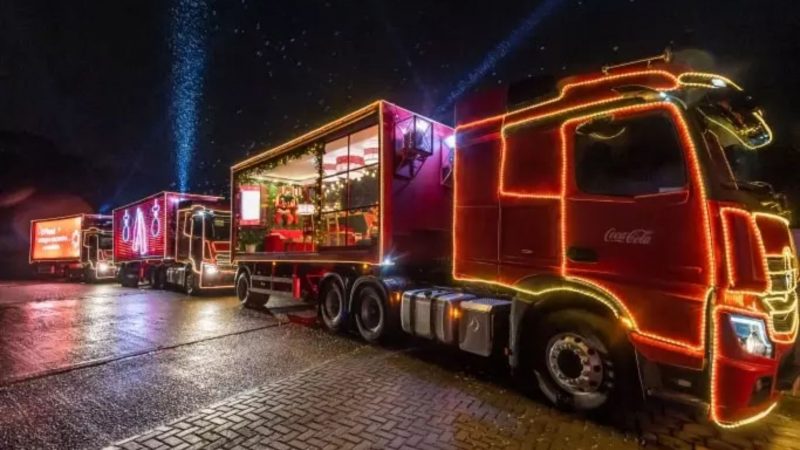 Caminhão com decoração natalina da Coca-Cola todo iluminado durante a nota