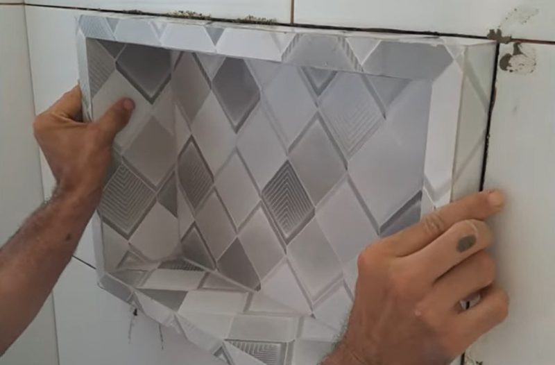 Pedreiro encaixa nicho feito à mão em parede de banheiro