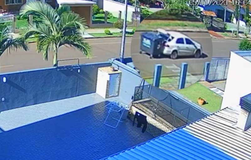 Lixeira amarrada no carro branco sendo levada por rua do Paraná. 