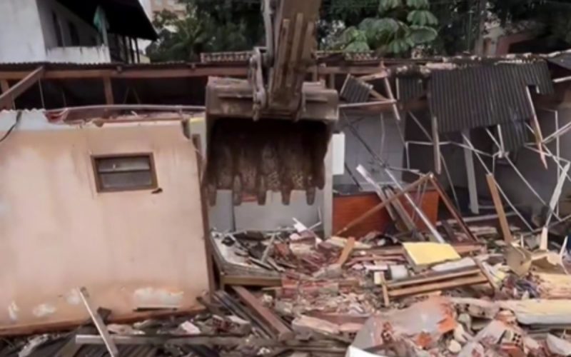 Escavadeira vista de dentro durante processo de demolição