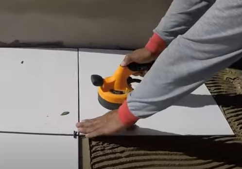 Pedreiro mostra máquina para assentar piso e porcelanato