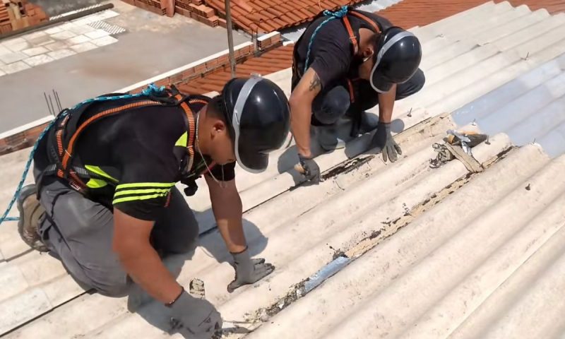 Pedreiros limpam toda a extensão do telhado