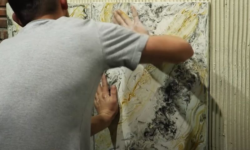 Pedreiro instala placas de gesso imitando porcelanato no reboco