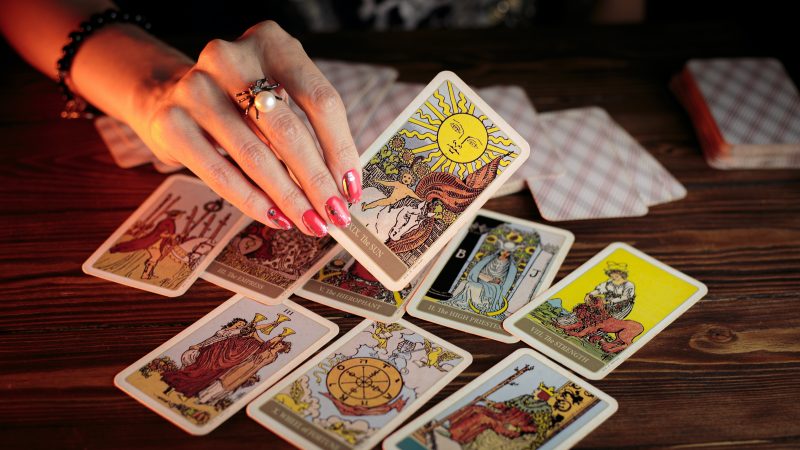 Imagem mostram uma série de cartas do tarot, uma delas indica como será 2024 para o signo de virgem