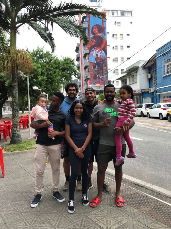 Família da artista Valda Costa posa em frente ao grande mural pintado em homenagem a ela no Centro de Florianópolis