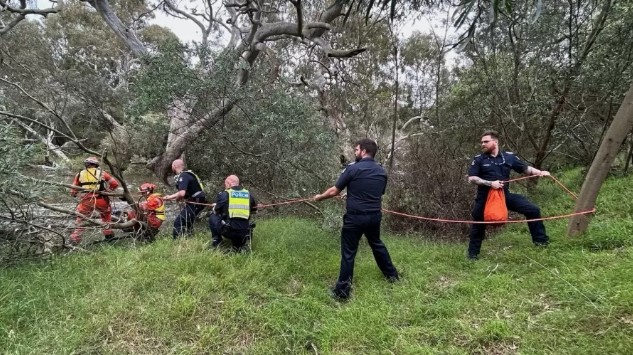 Fortes tempestades atingiram a Austrália. Na foto, bombeiros puxando corda por baixo de escombros.