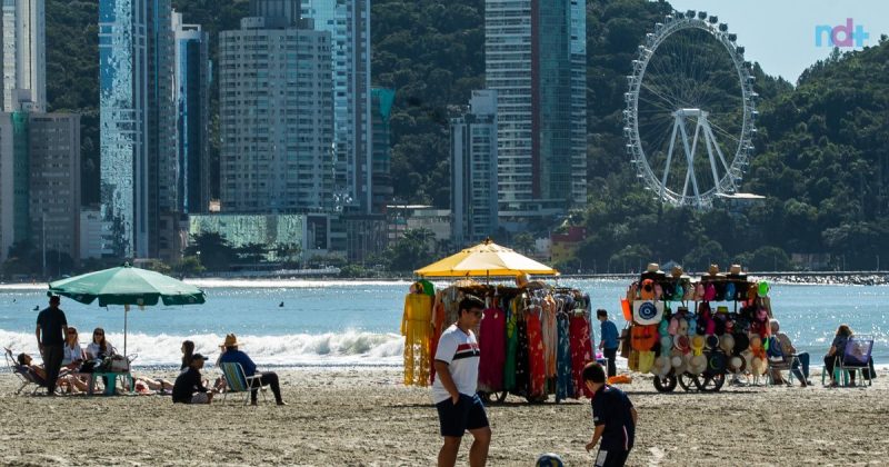 Foto mostra movimentação na faixa de areia da praia Central de Balneário Camboriú; Cidade está entre as favoritas dos turistas