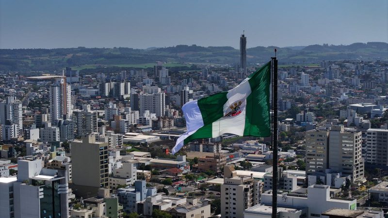 vista do alto da cidade de chapecó com a bandeira do município em primeiro plano; debate da ndtv record 