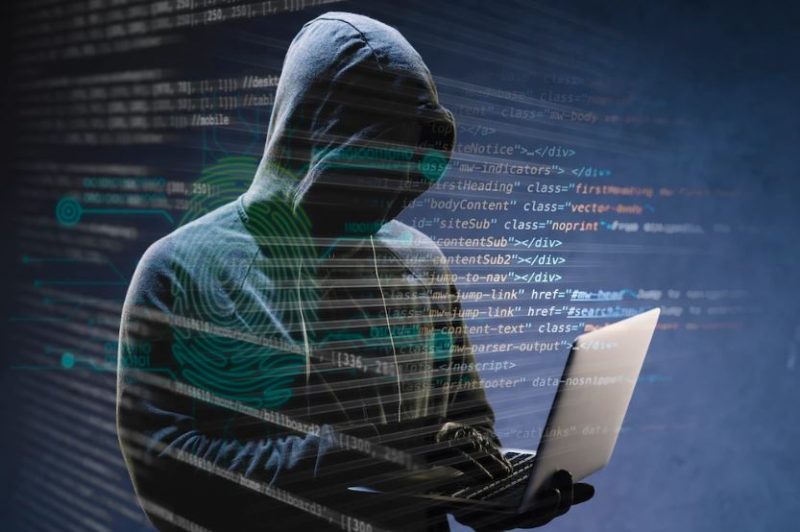 Illustrative image of a hacker in sweatshirt decoding codes on a laptop