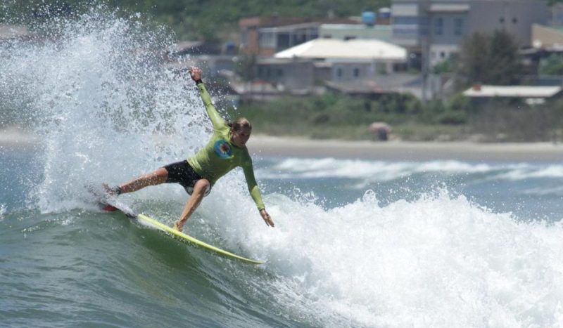 Foto mostra Jacqueline Silva praticando surfe em Florianópolis