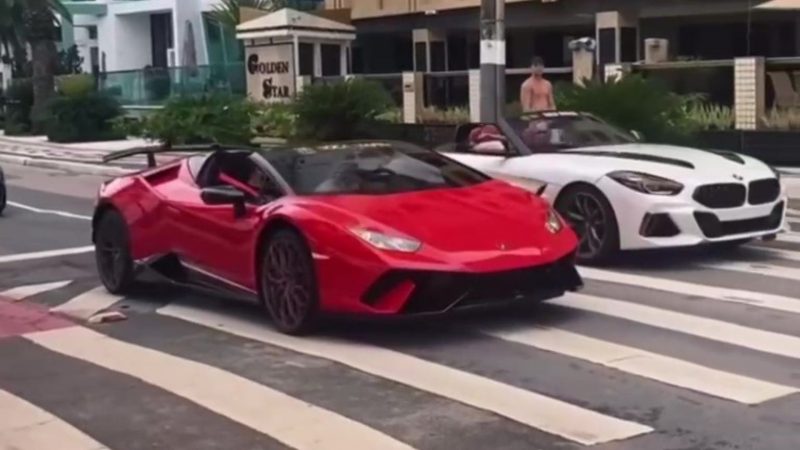 Carros de luxo flagrados na avenida Atlântica passando em lombada e faixa de pedestres; à esquerda, Lamborghini Vermelha conversível, à direita uma BMW branca e preta também conversível